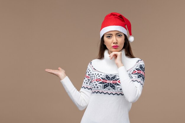 Front view young woman with thinking expression on brown background holiday emotions christmas