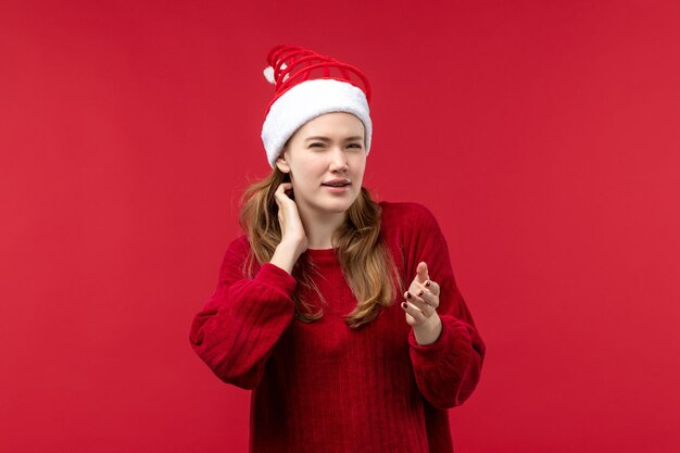 Вид спереди молодая женщина с выражением мышления на красном столе рождественский праздник красный
