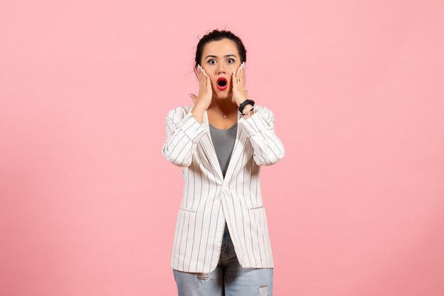 Front view young woman with white jacket and shocked face on pink background lady emotions fashion feeling color woman
