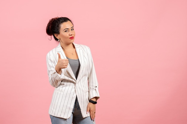 Front view young woman with white jacket showing awesome sign on pink background clothing lady emotions color fashion woman