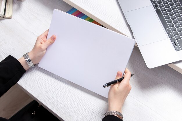 A front view young woman working with empty blanks in front of table with laptops job activity business