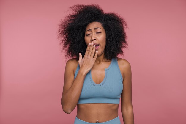 Front view of a young woman yawning