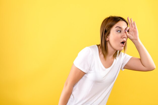 Front view of young woman on yellow wall