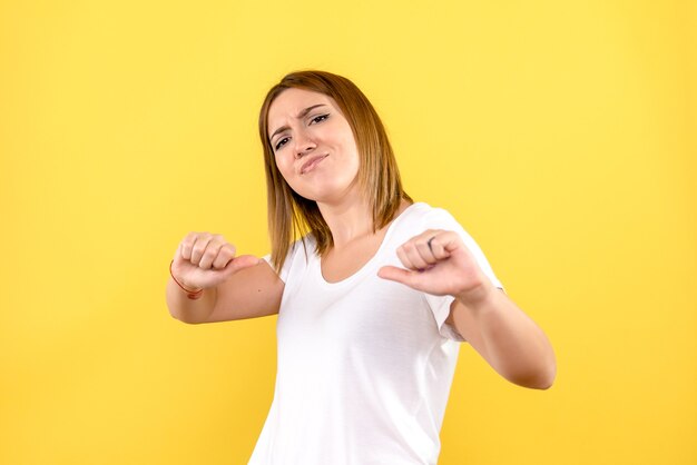 Front view of young woman on yellow wall