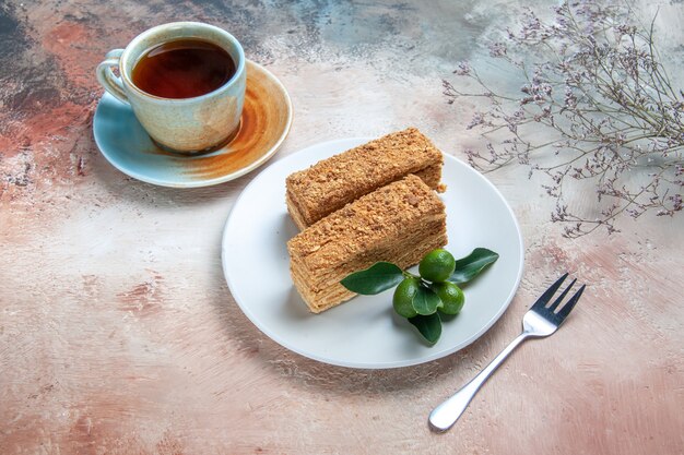 Front view yummy cake slices honey cake with tea on light 