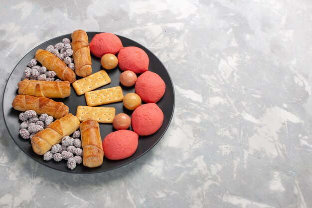 Front view yummy cakes with bagels and candies on the grey-white surface cake biscuit cookies sugar sweet pie