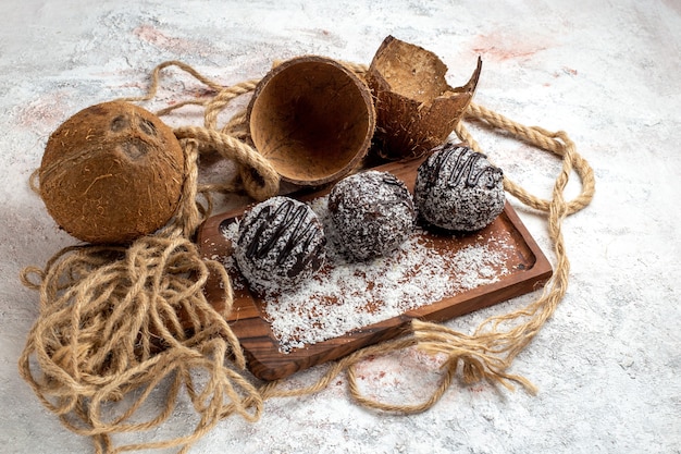 Vista frontale gustosissime torte al cioccolato con cocco su superficie bianco chiaro cuocere il biscotto zucchero torta biscotti dolci al cioccolato