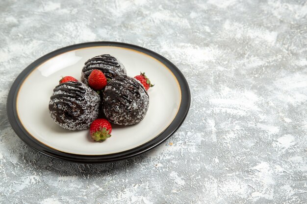 Front view yummy chocolate cakes with strawberries on the white surface bake biscuit sugar cake sweet cookie chocolate