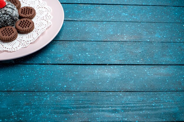 Вид спереди вкусное шоколадное печенье с шоколадным тортом на синем столе, торт, какао-чай, сладкое бисквитное печенье