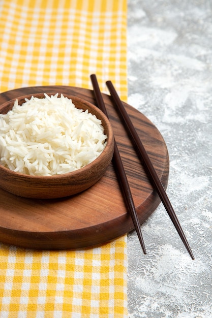 Front view yummy cooked rice inside brown plate on white desk