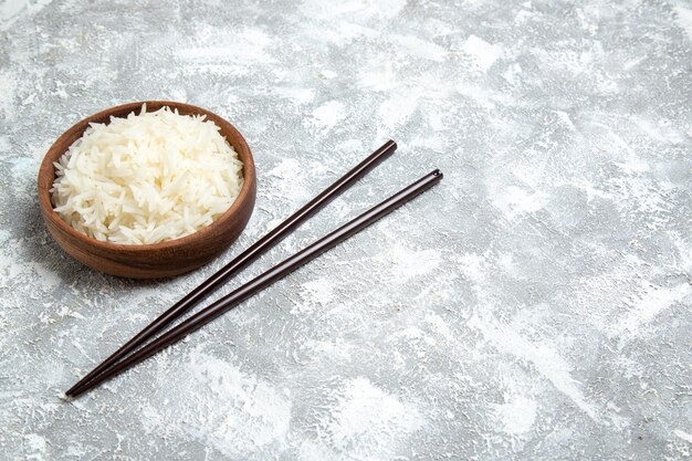 Front view yummy cooked rice inside brown plate on the white space