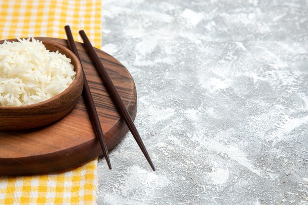 Front view yummy cooked rice inside brown plate on white space