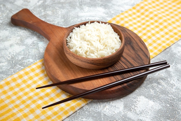 Front view yummy cooked rice inside brown plate on white space