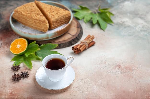 Free photo front view yummy honey cake with cup of tea on light