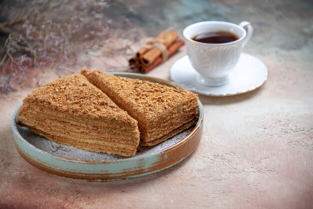 Free photo front view yummy honey cake with cup of tea on light