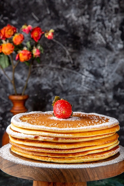 Front view yummy honey cake with sugar powder on round wooden board dark surface