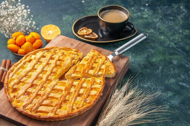 front view yummy kumquat pie with sliced one piece and cup of coffee on dark background