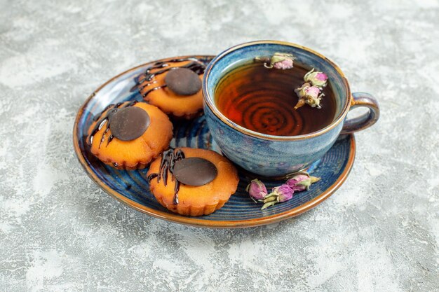 Front view yummy little cakes with cup of tea on white background cake biscuit cookie dessert tea sweet