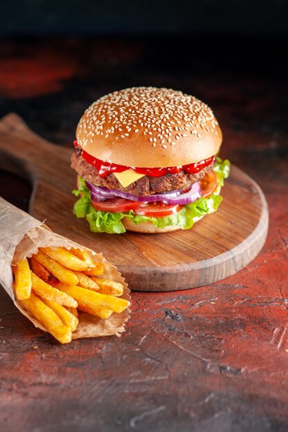 Foto gratuita vista frontale delizioso cheeseburger di carne con patatine fritte su sfondo scuro insalata cena hamburger snack fast-food piatto sandwich toast