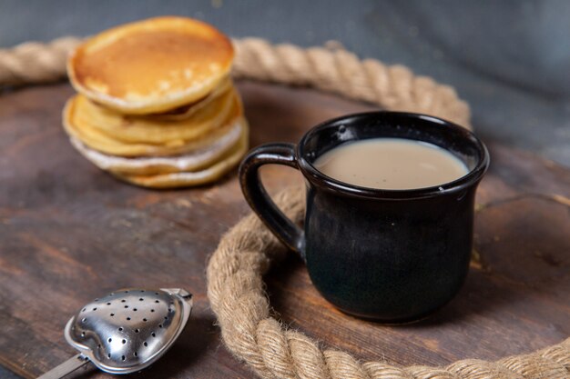Вид спереди вкусные кексы, запеченные с черной чашкой молока на сером фоне, еда, завтрак, еда, сладкий сахар