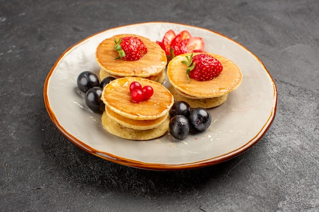 Free photo front view yummy pancakes little formed with fruits on dark surface fruit cake pie