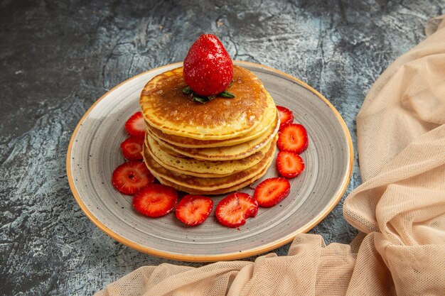 Front view yummy pancakes with fresh strawberries on light surface cake sweet fruit