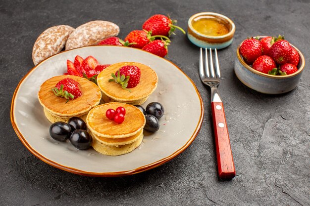 Front view yummy pancakes with fruits on dark surface fruit pie cake sweet