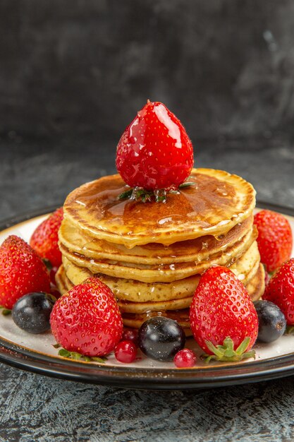 Front view yummy pancakes with fruits and honey on light surface breakfast sweet fruit