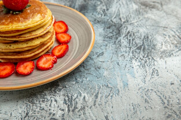 正面図明るい表面に蜂蜜とイチゴが入ったおいしいパンケーキケーキフルーツスウィート