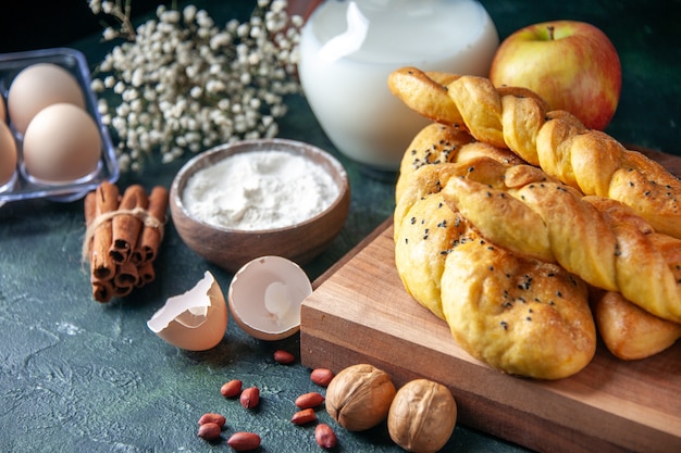 Front view yummy pastries with eggs flour and milk on a dark wall bread food meal breakfast morning milk bird color