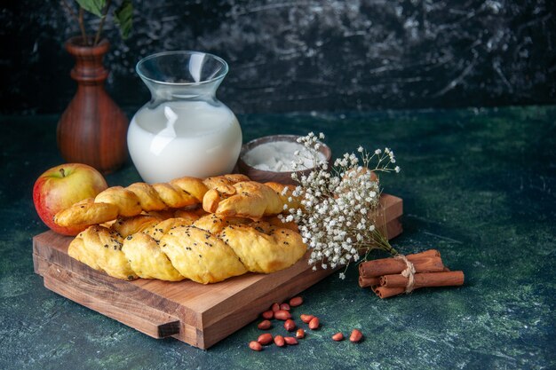 Вид спереди вкусная выпечка с мукой и молоком на темном столе, пирог, горячий пирог, сладкая булочка, десертное тесто, сахар
