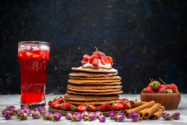 Вкусные круглые блинчики со свежей красной клубникой, корицей и клубничным коктейльным пирогом, вид спереди