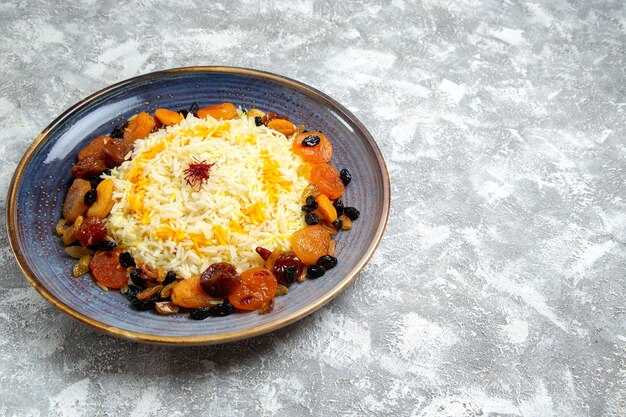 Front view yummy shakh plov cooked rice dish with raisins inside plate on the white space