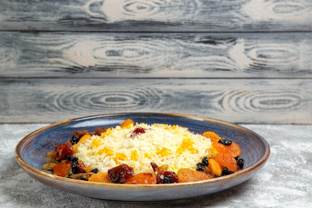 Foto gratuita vista frontale yummy shakh plov piatto di riso cotto con uvetta all'interno del piatto su spazio bianco
