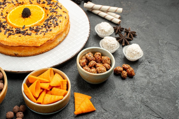 Front view yummy sweet pie with orange slices on dark-grey background dough fruit pie cake biscuit