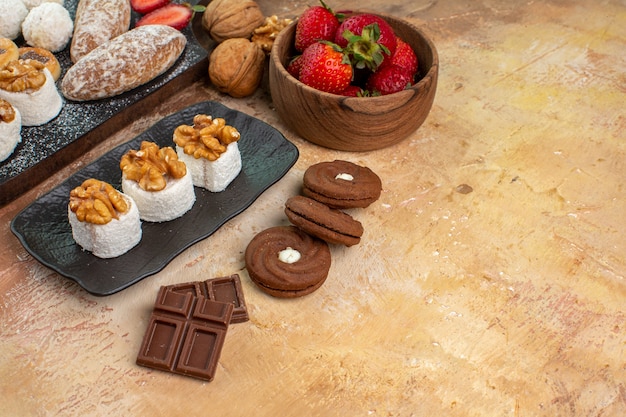 Free photo front view yummy sweets with fruits candies and cookies on a wooden desk