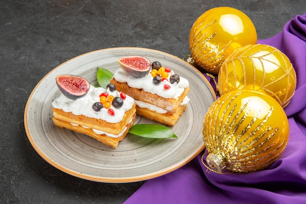 Front view yummy waffle cakes with fruits on a dark background