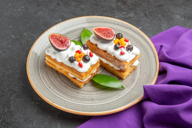 Free photo front view yummy waffle cakes with fruits on dark background