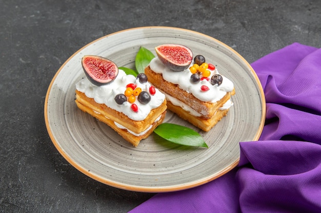 Front view yummy waffle cakes with fruits on dark background