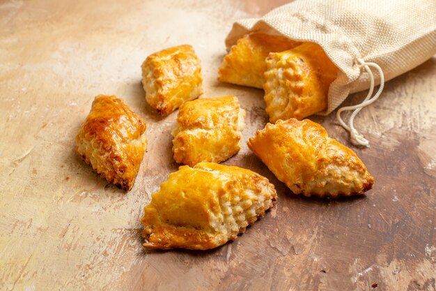 Front view yummy walnut pastries for tea on brown table sweet pastry pies cake