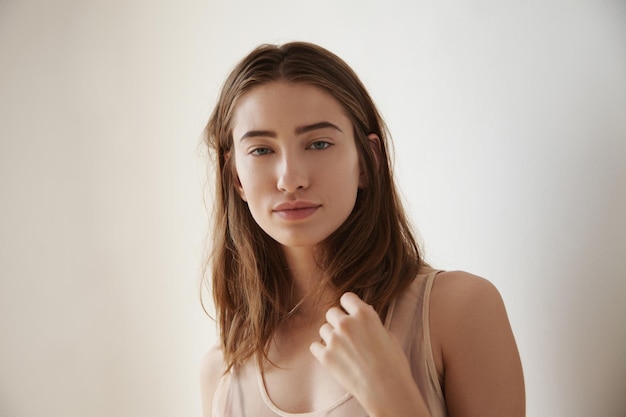 Frontal view portrait of woman touches her straight hair