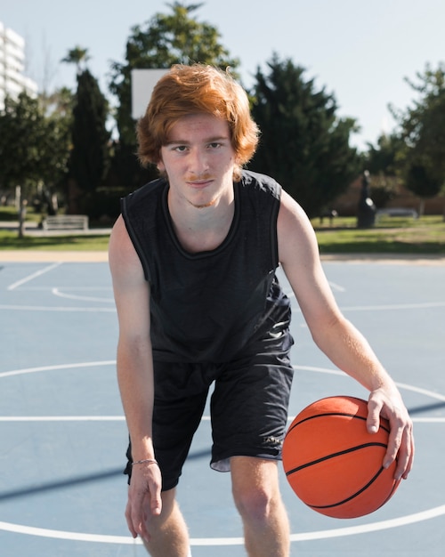 Free photo frot view of boy playing basketball