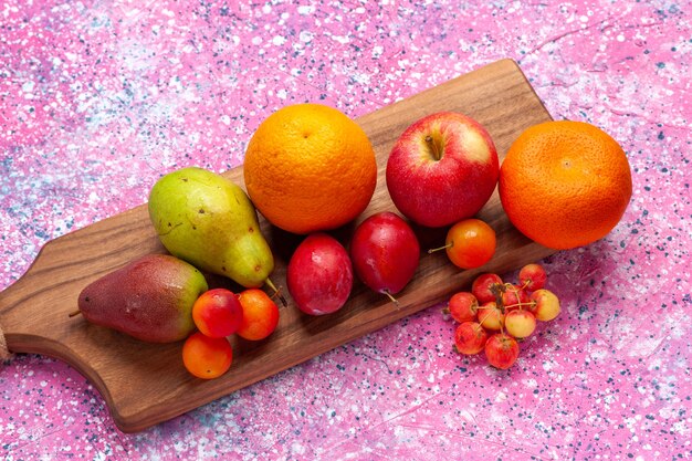 Foto gratuita frotn vista diversa composizione di frutta mandarini mele pere sullo scrittorio rosa.