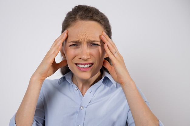 Frowning businesswoman suffering from headache