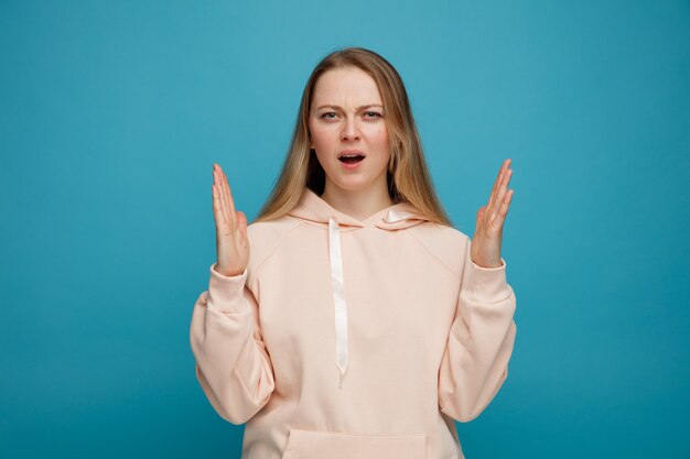 Frowning young blonde woman doing size gesture 