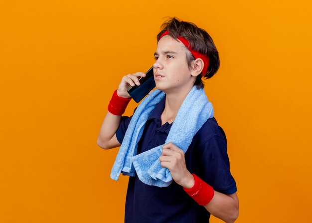 Frowning young handsome sporty boy talking on phone