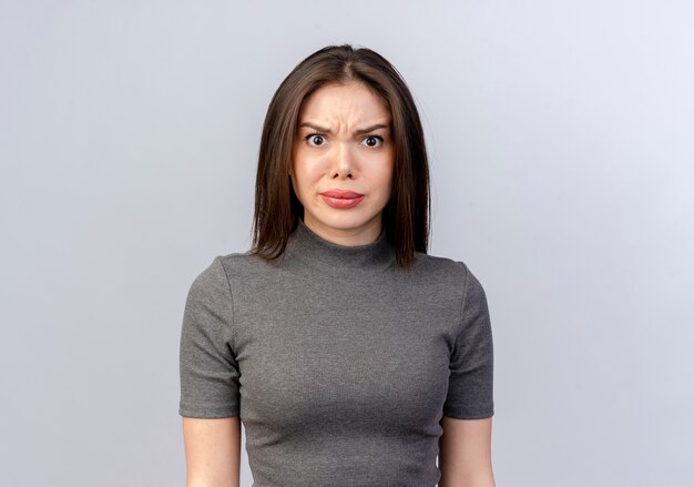 Frowning young pretty woman looking at camera isolated on white background with copy space