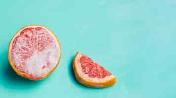 Free photo frozen grapefruit on turquoise background