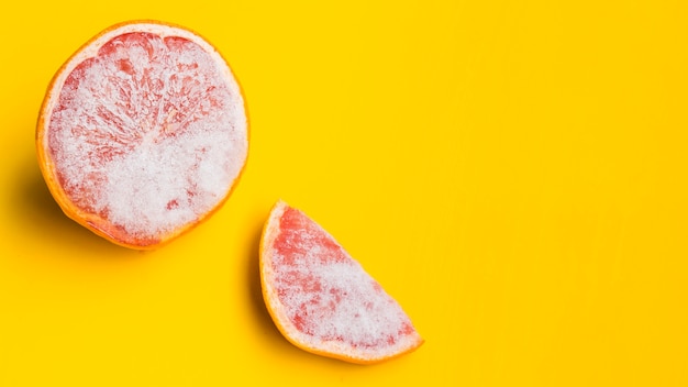 Замороженный грейпфрут на желтом фоне