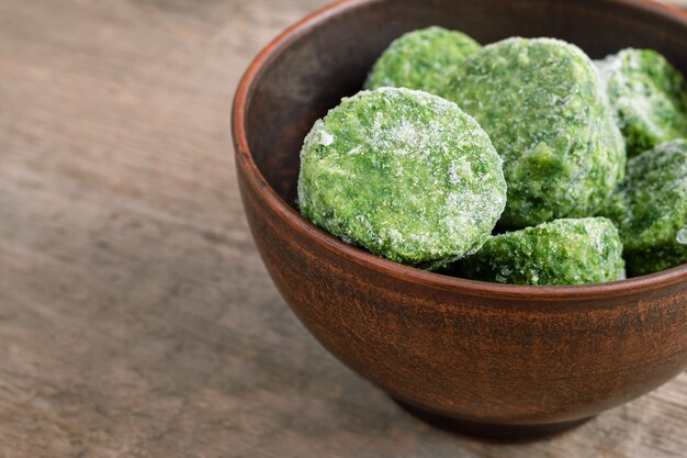 Frozen spinach on wooden background.